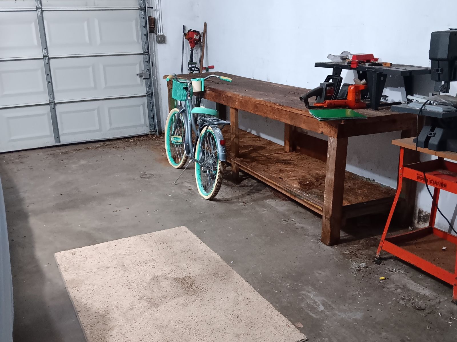 Garage workbench with tools and bike staged for removal