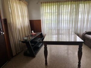 Living room with table and TV stand awaiting removal