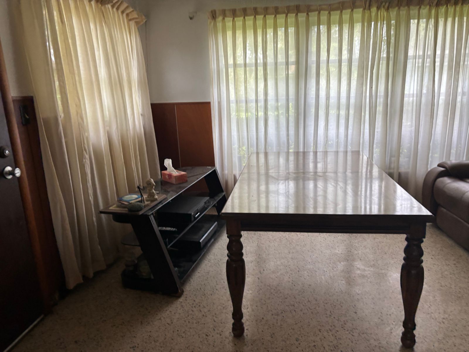 Living room with table and TV stand awaiting removal
