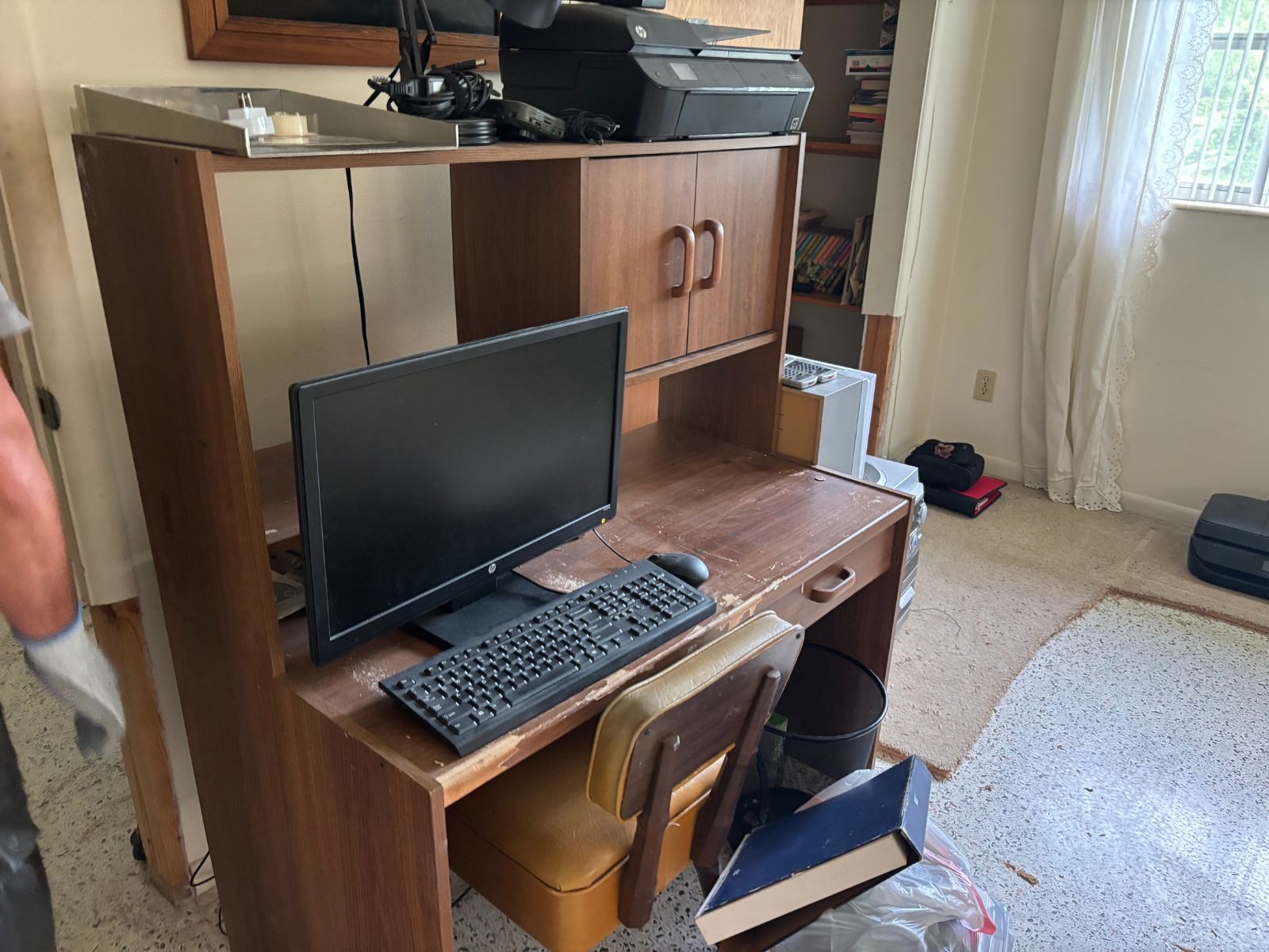 Computer desk with monitor and printer awaiting junk hauling