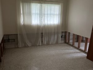 Room with drywall cut exposing studs during house cleanout